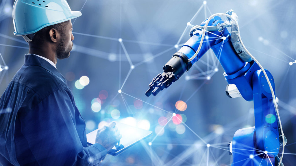 Builder with hardhat looking at industrial packaging and assembly in a robot